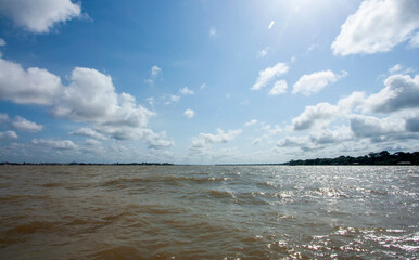 Rio Guamá em Belém do Pará em tarde ensolarada, com floresta e ilha do Combú no horizonte com...