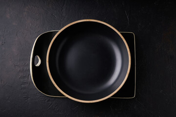 Black stone tray and bowl on a black background Copy space Dark photo Mock up
