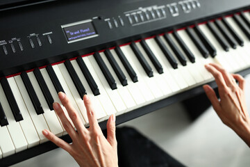 Obraz premium Beautiful female hands lie on a digital piano