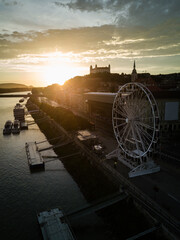 Bratislava ferris wheel, castle and Danube river drone photo at sunset