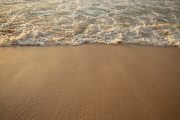 Scenic seascape. Milky foam waves at the beach. Sunset time. Waterscape for background. Selected soft art focus. Sunlight reflection on the water and sand. Balangan beach, Bali, Indonesia