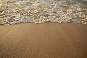 Scenic seascape. Milky foam waves at the beach. Sunset time. Waterscape for background. Selected soft art focus. Sunlight reflection on the water and sand. Balangan beach, Bali, Indonesia