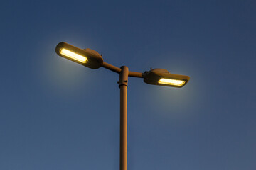 Poste de iluminação pública com luzes acesas.