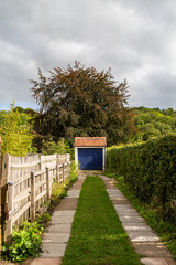 a path leading to a car garage a part of a countryside home