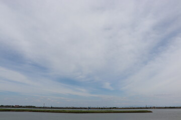 Fototapeta na wymiar 雲が多い日の川と空