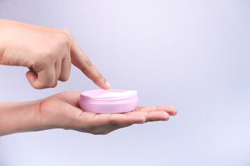woman applying beauty cream onto skin isolated in white 