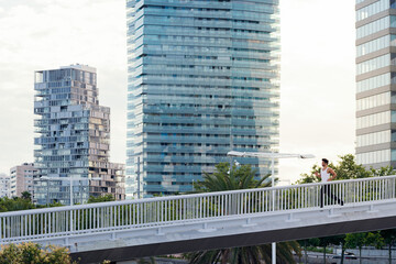 man running on a city bridge in front of buildings