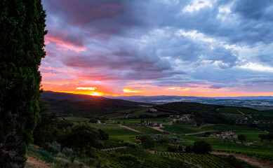 Fototapeta premium Spektakularny zachód słońca w Montalcino w Toskanii we Włoszech z winnicami i farmami w tle