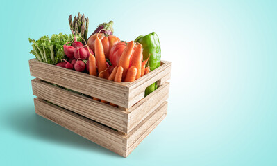 Wooden box with fresh vegetables, on blue background with copy space