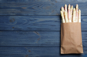 Fresh white asparagus on blue wooden table, top view. Space for text