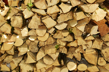 A stack of dry firewood. Preparation of firewood for the winter. Background from dry, chopped firewood.