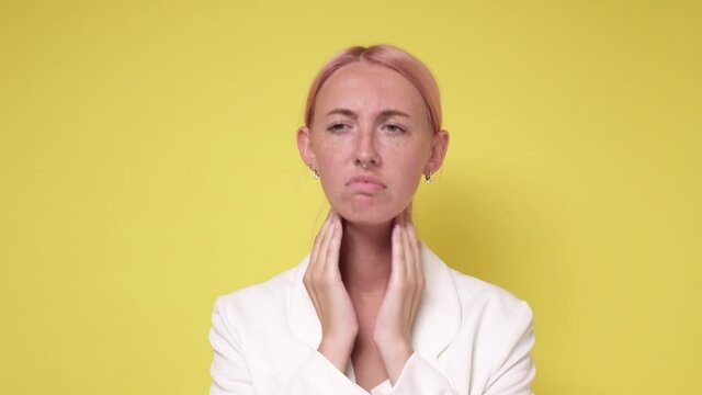 Young caucasian woman checking thyroid gland on yellow background