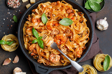 Italian fettuccine pasta with seafood. Seafood pasta with mussels, shrimp and octopus with basil in a cast iron pan