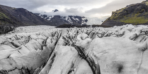 Landscape of badlands covered in ice under a cloudy sky in Iceland