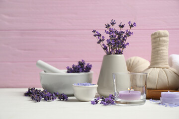 Obraz na płótnie Canvas Cosmetic products and lavender flowers on white wooden table