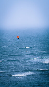 Vertical shot of a parasailer in the open sea