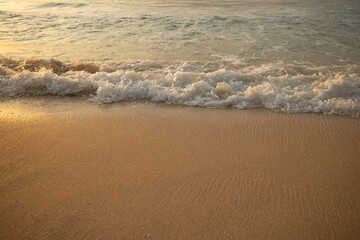 Scenic seascape. Milky foam waves at the beach. Sunset time. Waterscape for background. Selected soft art focus. Sunlight reflection on the water and sand. Balangan beach, Bali, Indonesia
