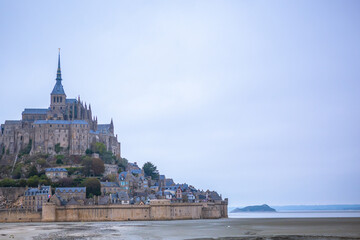 Fototapeta na wymiar Mont-Saint-Michel and its Bay on a cloudy day in Normandy, France.