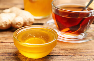 Tasty honey and tea on wooden table, closeup