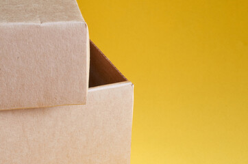 Corner of a brown cardboard box on a yellow background