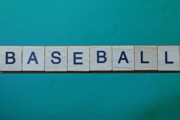 gray word baseball made of wooden square letters on green background