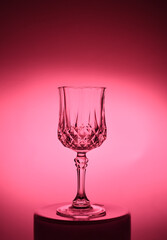 Wineglass on the light background. Fine cristal glassware concept. Vertical, toned in blue