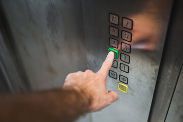 Hand finger presses the floor selection button in a modern elevator - high-speed elevator - start button © andrey gonchar