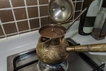 close up view of bronze cezve on gas making coffee