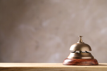 Hotel service bell on wooden table. Space for text