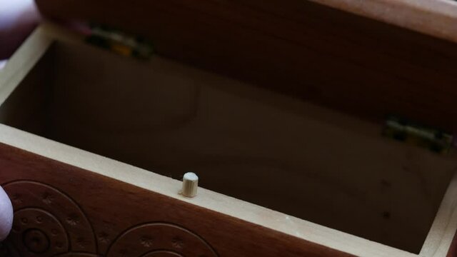 A man hand opens a wooden box. Brown background. Carved drawer lid. There is nothing in the box. Velvet dark cherry background. Effective transition for editing. Empty jewel storage. Treasure concept