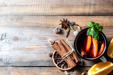 Hot christmas mulled red wine with spices and fruits on a wooden rustic table.