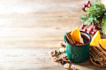 Hot christmas mulled red wine with spices and fruits on a wooden rustic table.