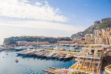 The coastal view of the port and boats in Monaco, on a sunny day.