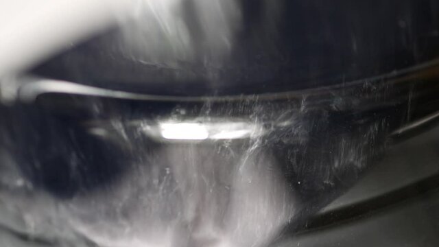 Things are spinning in drum of modern washing machine. Glass door of an automatic washing machine. Electric home appliance. Swirling clothes. Washing in water with addition of detergents.