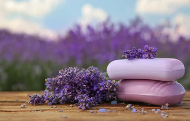 Foto op Canvas Fresh lavender flowers and soap bars on wooden table outdoors, closeup © New Africa