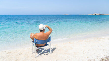 man in realx by the sea in the beach of is arutas in western sardinia