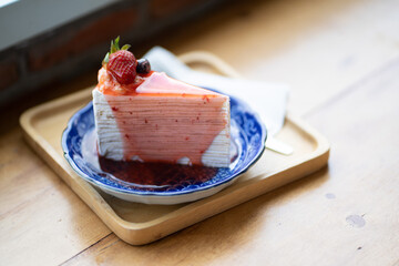 
One strawberry cake is placed on a wooden table.