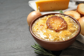 Tasty homemade french onion soup served on black table
