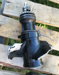 Bent gearbox and broken propeller of outboard motor.