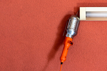 garage. Concrete walls to be painted. An orange carrier hangs on it for inspection of the car and their further repair.