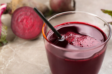 Freshly made beet juice in glass on grey table, closeup