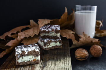Chocolate milk biscuits with raisins on a wooden, vintage board, decor with autumn leaves, walnuts...