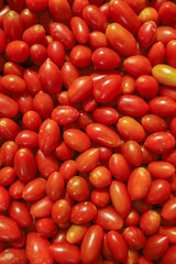 Lots of red tomatoes at bazaar. agriculture farm full of organic vegetables. Pile of ripe tasty red tomatoes in the store. Top view of tomatoes. Food background (selective focus)