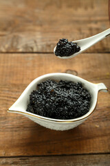 Fototapeta na wymiar Spoon with black caviar in female caviar over caviar.