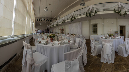 many tables and chairs at a white wedding panorama