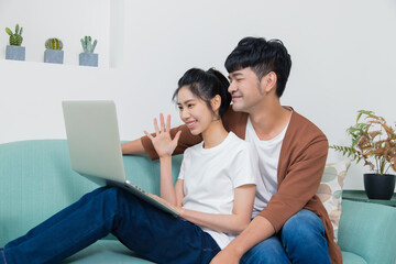 Happy young couple talking through the computer with video chat.