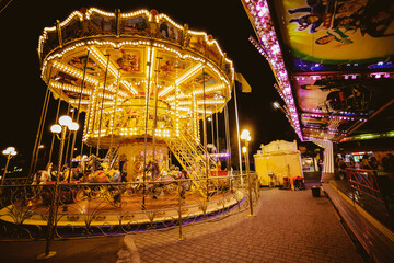 Children's Carousel at an amusement park in the evening and night illumination. amusement park at night. amusement park, picture for the background. © Vladibulgakov