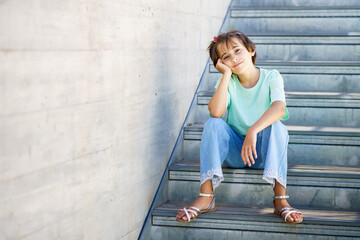 9-year-old girl posing happily on a staircase