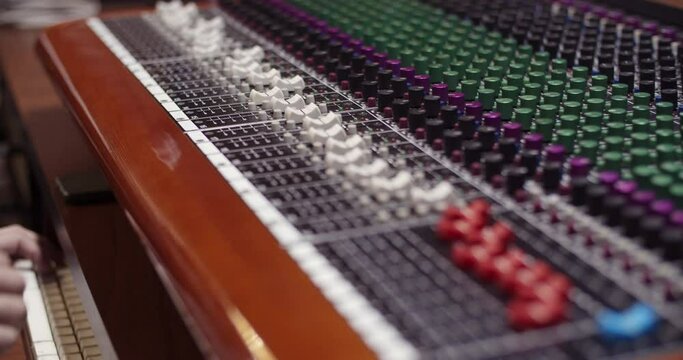Man in a control room of a recording studio moving a fader with a Toft console / Professional recording studio / 4K at 60fps (slowmotion) / Professional audio vives