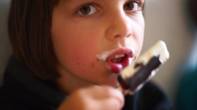 Teenager eats ice cream after eating. Sweet cold dessert cheers up the child. Pleasant moments of joy in life.